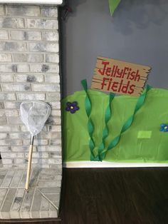 a green bag sitting on top of a hard wood floor next to a brick wall