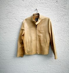 Italian  nappa leather bomber style  jacket in color tan with zipper, long sleeves, multiple pockets , fully lined.  The jacket is  in good  used condition. Size on tag: IT 48, please check measures for correct fit! Estimated fit: medium Condition: 8/10 Flat Measures  Pit to pit: 56 cm - 22'' Sleeves: 66 cm - 26''  Length from collar on back: 64 cm - 25'  Add my store to Favorites and Follow my Shop for new items. DELIVERY: For new updates on delivery please see my Shops front page! Thank you fo Vintage Beige Leather Jacket With Long Sleeves, Vintage Beige Leather Outerwear, Beige Leather Jacket With Zipper Closure, Spring Single-breasted Brown Leather Jacket, Beige Single-breasted Leather Jacket, Tan Leather Jackets, Vintage Single-breasted Leather Outerwear, Cropped Zip Up, Sleeveless Knit Top