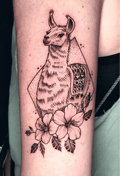 a black and white tattoo with an animal on it's arm, surrounded by flowers