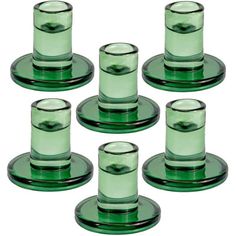 six green glass cups and saucers on a white background