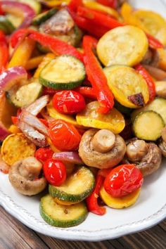 a white plate topped with vegetables on top of a wooden table