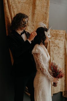 a bride and groom are dressed up in masks