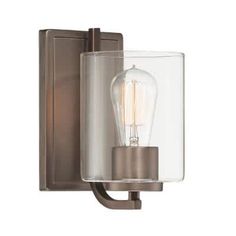 a wall light with a clear glass shade on the front and back of it's arm