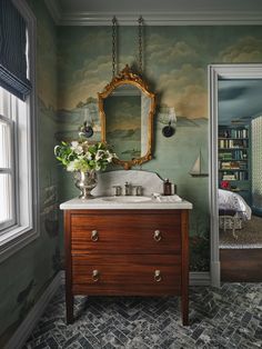 a bathroom with green walls and a wooden vanity topped with a mirror next to a window