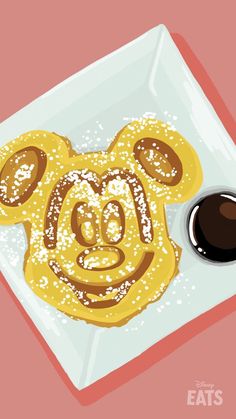 a plate topped with pancakes covered in powdered sugar and a bear face drawn on it