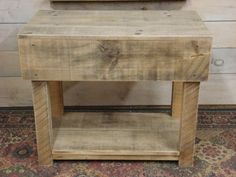 a small wooden table with a mirror on it's top and an old rug in the background