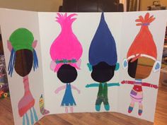 three children's paper cut outs with different colored hair styles and colors on them