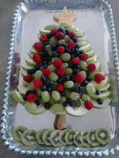 a fruit christmas tree made out of kiwis, raspberries and bananas