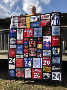 a man is holding up a quilt made with beer bottles and t - shirts on it