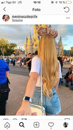 a woman with long blonde hair wearing a mouse ears headband and carrying a white purse