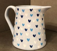 a blue and white vase with hearts painted on it