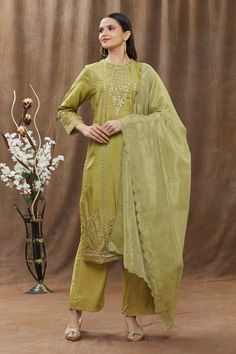 Henna green kurta with thread and sequin floral embroidery. Comes with pant and dupatta.
Component: 3
Pattern: Embroidery
Type Of Work: Thread and Sequin
Neckline: Round
Sleeve Type: Full
Fabric: Chanderi
Color: Green
Other Details: 
Dupatta with scalloped border
Side slits
Pants with scalloped lace trim
Occasion: Puja - Aza Fashions Pista Green Palazzo Set With Mirror Work, Pista Green Straight Kurta Sets With Mirror Work, Pista Green Sets With Mirror Work And Straight Kurta, Pista Green Dola Silk Sets With Resham Embroidery, Pista Green Chanderi Set With Resham Embroidery, Pista Green Palazzo Set With Mirror Work For Diwali, Diwali Pista Green Palazzo Set With Mirror Work, Pista Green Sets With Mirror Work For Eid, Designer Wear Green Sets With Resham Embroidery