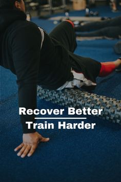 a man doing push ups on a blue mat with the words recover better train harder