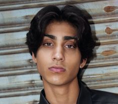 a young man wearing a black shirt and tie