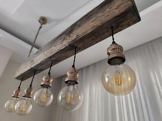 five light bulbs hanging from a wooden beam