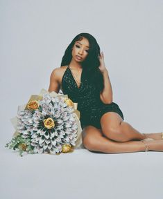 a woman sitting on the floor next to a bouquet