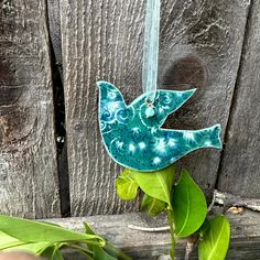 a blue bird ornament hanging on a wooden fence