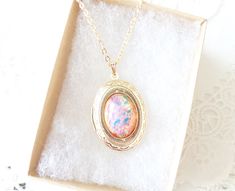 "A gorgeous gold plated photo locket adorned with a lovely pink fire opal dangles so pretty from a 16k gold plated link chain with lobster clasp. Total length of chain measures 18\" Locket measures 23x30mm Fire Opal measures 18x13mm Locket is high quality and nickel free Please note that this is not a real opal, but a faux opal glass cabochon with incredible fire and flecks of blue, yellow, green and pink Opal being the birthstone for October makes this a perfect birthday gift Your purchase will Gold Locket Necklace For Birthday, Gold Locket Necklace For Birthday Gift, Gold Locket Necklace With Birthstone For Gift, Gold Oval Pendant Jewelry For Birthday, Pink Fire, Gold Locket Necklace, October Birthday, Gold Locket, Photo Locket