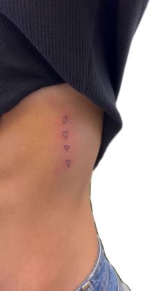 a woman's stomach with small hearts on the side and one heart in the middle