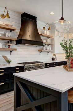 a kitchen with black cabinets and white counter tops