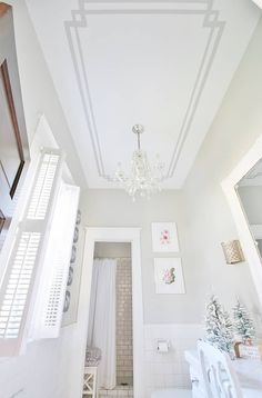 a white bathroom with a chandelier hanging from the ceiling