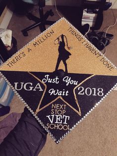 a graduation cap with the words just you, uga await on it in gold and black