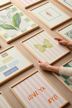 a woman is holding up some art work on the floor with words and butterflies all over it