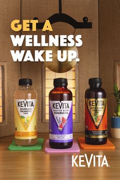 three bottles of kevita tea sitting on top of a wooden table