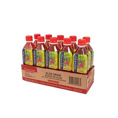 six bottles of aloe drink sitting on top of a cardboard box filled with orange juice