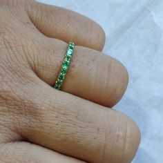 **KINDLY CHECK OUT THE VIDEO OF THE ITEM FOR A CLEARER VIEW**Details of the ring Gem: Emerald Gem size: 2 mm (9 pec ) Gem shape-Round Gem weight: 0.26 carats Gold purity: 14KT (58.33% approx.) Gold weight: 0.86 gms Total weight of ring:0.91 gms Ring size us 6 Diamond cut Natural Emerald Gemstones set in Solid 14KT Yellow Gold. The Gold purity is guaranteed and it comes with authentic 14 kt gold hallmark. Since these Rings are handmade, Size Customization is available for this ring and it is avai Green Eternity Band With Prong Setting As Gift, Green Stackable Eternity Band For Anniversary, Green Prong-set Eternity Band For Anniversary, Green Eternity Band With Prong Setting For Anniversary, Green Vvs Clarity Eternity Band For Anniversary, Green Half Eternity Band For Anniversary, Green Prong-set Eternity Band For Promise Ring, Green Eternity Band With Vvs Clarity In Round Shape, Green Half Eternity Round Band