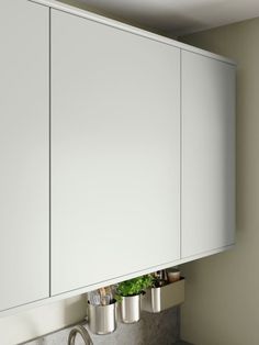 a kitchen with white cabinets and stainless steel sink