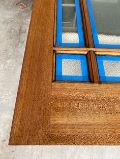 a close up of a wooden door with blue glass inserts on the bottom and sides