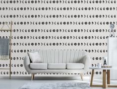 a white couch sitting in front of a wall with circles on it