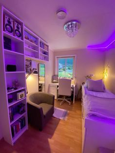 a room with a bed, desk and book shelf in the corner is lit up by purple lighting