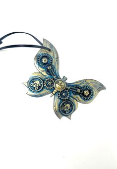 a blue and white butterfly ornament hanging from a black cord on a white background