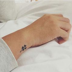 a person's arm with a small tattoo on the left side of their wrist