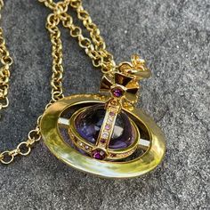 This Vivienne Westwood Necklace Is A Stunning Piece Of Fashion Jewelry. The Gold Chain Features A Giant Orb Pendant In A Beautiful Shade Of Purple. The Necklace Has A Stylish Charm That Will Make It A Perfect Accessory For Any Outfit. With Its Unique Style, This Necklace Is Sure To Stand Out And Make A Statement. The Vivienne Westwood Logo Adds A Touch Of Luxury To This Beautiful Piece. Perfect For Those Who Want To Add A Touch Of Elegance And Sophistication To Their Look. Things To Note: * In Beautiful Preloved Condition * Box And Dust Bag Not Included * 100% Authentic Jewelry Vivienne Westwood, Vivienne Westwood Necklace, Vivienne Westwood Logo, Westwood Necklace, Vivienne Westwood Orb, Vivienne Westwood Jewelry, Orb Necklace, Vivienne Westwood Jewellery, Gold And Purple