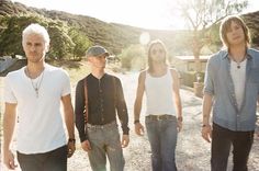 four young men walking down a dirt road