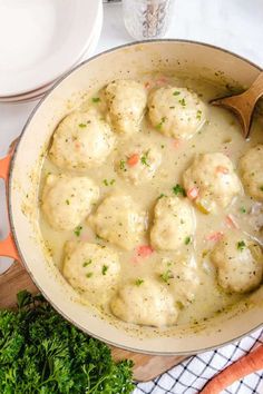 a pot filled with meatballs and gravy on top of a wooden cutting board