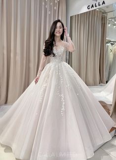 a woman standing in front of a mirror wearing a wedding dress with flowers on it