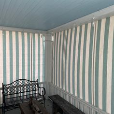 a bench sitting next to a window covered in vertical blinds