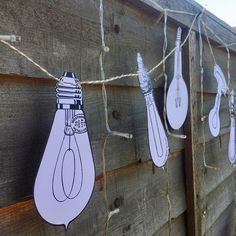 some light bulbs are hanging on a fence