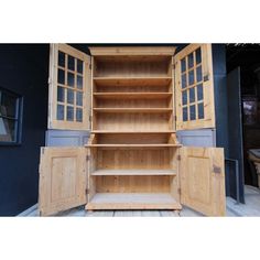 an open wooden cabinet sitting on top of a wooden floor