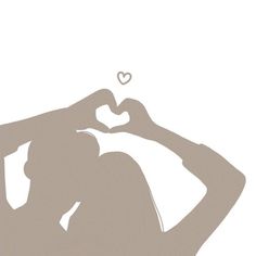 the silhouette of a woman making a heart shape with her hands while standing in front of a white background