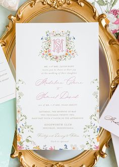 the wedding stationery is laid out on a gold plate