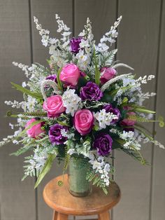 a vase filled with lots of purple and white flowers