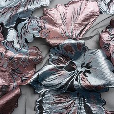 metallic fabric with flowers and leaves on the back in pink, silver and blue colors