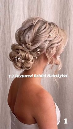 a woman with blonde hair and flowers in her hair is wearing a wedding hairstyle