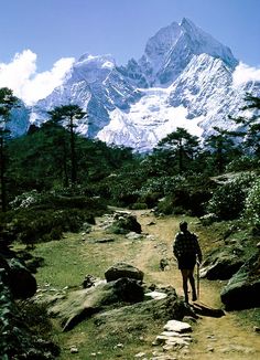 a man hiking up a trail in the mountains