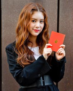 a woman holding up a red piece of paper